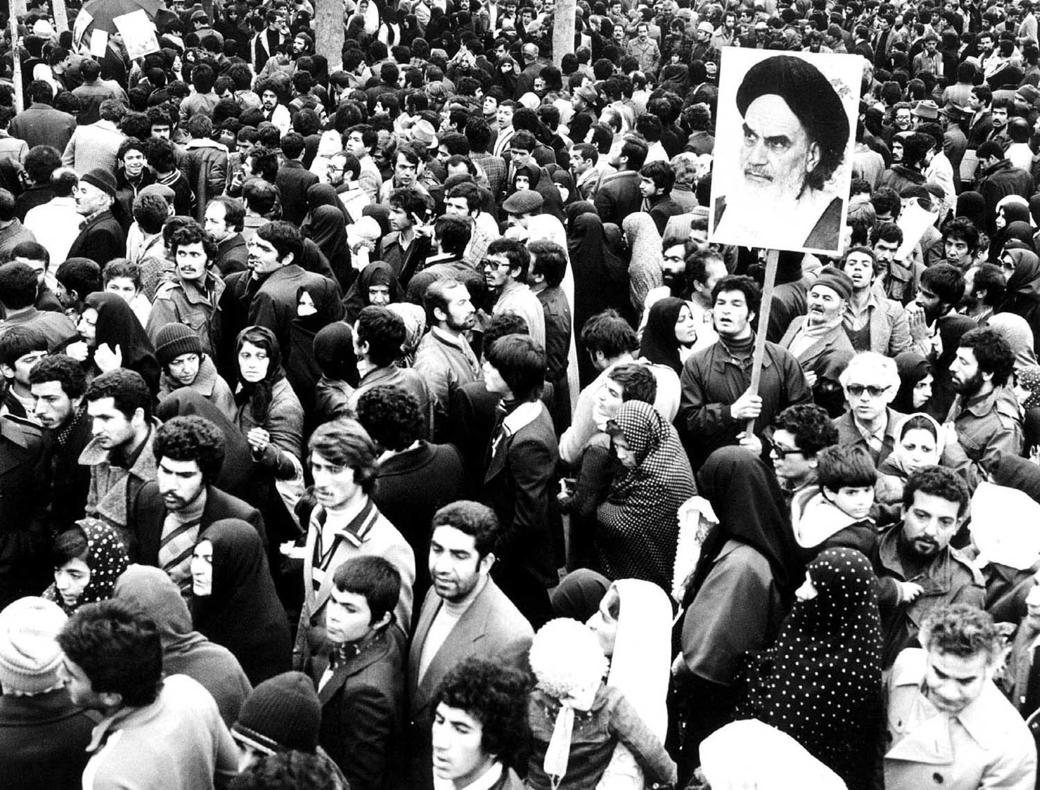 IRANIANS HOLD PICTURE OF KHOMEINI DURING THE REVOLUTION.